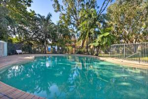 a swimming pool in a yard with trees and a fence at Bay Parklands 44 WI FI Netflix Air Con and Views in Nelson Bay