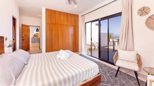 a bedroom with a bed and a chair and a balcony at Villa Damiana Luxury Hotel in El Pescadero +29 photos