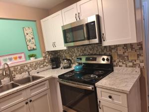 a kitchen with a stove and a microwave at Mozzy-Love Room in Orlando