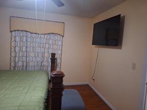 a bedroom with a bed and a flat screen tv at Mozzy-Love Room in Orlando