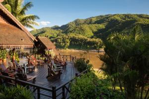 a resort deck with chairs and a view of a river at The Luang Say Lodge in Pakbeng