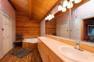 a bathroom with a sink and a mirror and a tub at Red Roof Lodge - Leavenworth in Leavenworth +16 photos