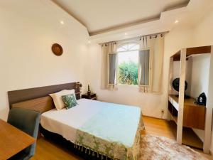 a bedroom with a bed and a window at Suite casal com frigobar in Belo Horizonte