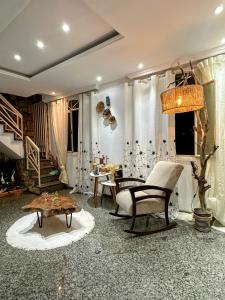 a living room with a couch and chairs and a table at Suite casal com frigobar in Belo Horizonte