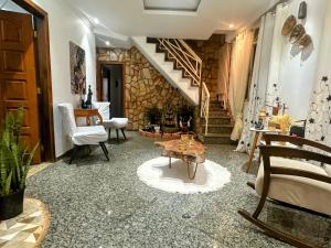 a living room with a staircase and a table at Suite casal com frigobar in Belo Horizonte