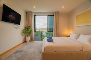 a bedroom with a large bed and a large window at Modern 4BR Villa with Private Pool in Bangtao in Bang Tao Beach