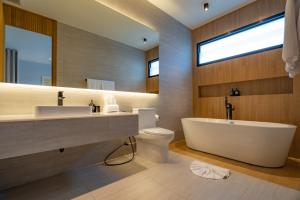 a bathroom with a tub and a toilet and a sink at Modern 4BR Villa with Private Pool in Bangtao in Bang Tao Beach