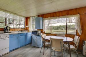 a kitchen with blue cabinets and a table with chairs at Honesdale Cabin 110 Shared Acres, Animal Rescue! in Honesdale