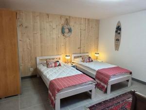 two beds in a room with wooden walls at Le Phare in Agon Coutainville