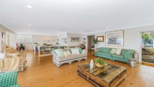 a living room with couches and a table at Absolute Beachfront Beauty - Pearl Beach in Pearl Beach +16 photos