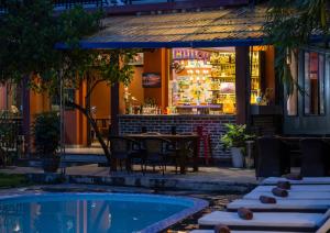 吉婆岛Catba Backpackers - Sea Vibe Pool Bar & Bungalow的池畔餐厅,配有桌椅