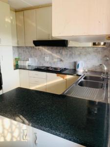 une cuisine avec un évier et un plan de travail dans l'établissement KwaMgozimba guest house 1 Room3 or 5, à Durban