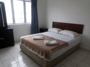 a bedroom with a bed with two towels on it at Plaza Melaka Raya Serviced Apartment di tengah Bandar Melaka in Malacca