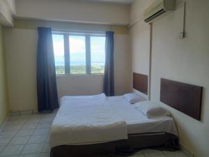 a bed in a room with a large window at Plaza Melaka Raya Serviced Apartment di tengah Bandar Melaka in Malacca