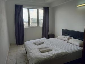 a bedroom with a bed with two towels on it at Plaza Melaka Raya Serviced Apartment di tengah Bandar Melaka in Malacca