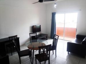 a living room with a glass table and chairs at Plaza Melaka Raya Serviced Apartment di tengah Bandar Melaka in Malacca