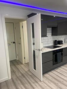 a kitchen with black and white cabinets and a counter at Lovely Modern studio flat with jacuzzi bath free parking in Stanwell