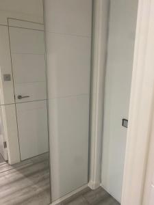 a glass walk in shower in a room at Lovely Modern studio flat with jacuzzi bath free parking in Stanwell