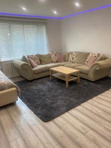 a living room with a couch and a coffee table at Lovely Modern studio flat with jacuzzi bath free parking in Stanwell