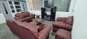 Una sala de estar con sofás, una mesa y un televisor. en Casa IRKEN, en San Pablo Apetatitlán