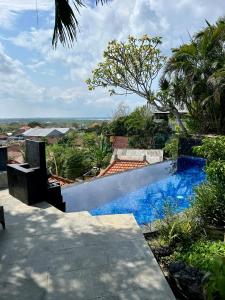 Una piscina con agua azul en un patio. en View apartments with infinity pool in Nusa Dua Bukit Renovated in 2025, en Nusa Dua