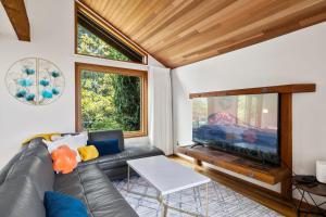 a living room with a couch and a large flat screen tv at CapHill Charm in Seattle
