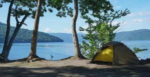 ein Zelt am Ufer eines Sees mit Bäumen in der Unterkunft Towada City Utarube Campsite - Vacation STAY 00407v in Utarube