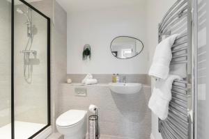a bathroom with a shower and a toilet and a sink at Elliot Oliver - Beautiful Two Bedroom Apartment With Parking in The Docks in Gloucester