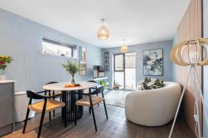 a kitchen and living room with a table and chairs at Elliot Oliver - Beautiful Two Bedroom Apartment With Parking in The Docks in Gloucester