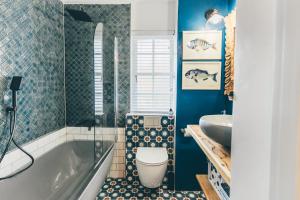 a bathroom with a tub and a toilet and a sink at The Kingfisher in Plettenberg Bay