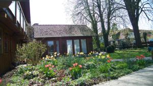 a garden of flowers in front of a house at Ferienhaus Kastaniengrün in Worpswede