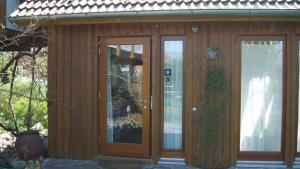 a wooden house with two doors and a window at Ferienhaus Kastaniengrün in Worpswede