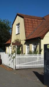 a yellow house with a white picket fence at Atelierhaus Tannenweg in Worpswede