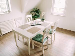 a dining room table with chairs and a white table at Ferienwohnung Worpsweder Schlösschen in Worpswede