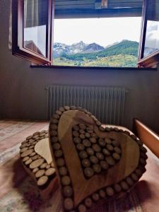 a heart shaped chair sitting in front of a window at Chalet Nontiscordardime in Cogolo +7 photos