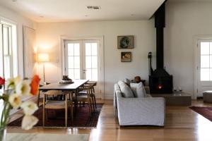 a living room with a couch and a table and a stove at Alkina Old Quarter Luxury Accommodation in Greenock