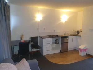 a living room with a kitchen with a counter top at AAA Mana Motel in Porirua