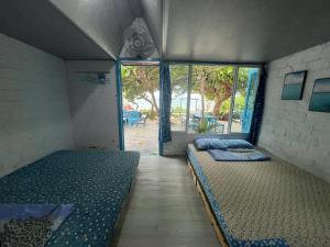 a room with two beds and a window at nhà Ba cơm Má in Phương Phi
