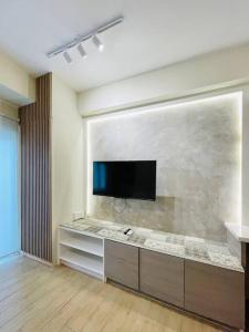 un salon avec une télévision à écran plat sur un mur dans l'établissement 18 Warm Studio Oasis, à Cari Mayor