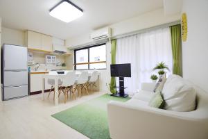 a living room with a white couch and a kitchen at Hostel Inn Tokyo Ryogoku in Tokyo