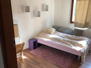 een kleine slaapkamer met een bed en een bank bij Schlosspark Bungalow in Seebenstein +23 foto's