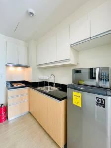 une cuisine avec des armoires blanches et un réfrigérateur en acier inoxydable dans l'établissement 19 Cityscape Views, à Cari Mayor