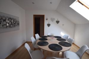 a dining room with a table and white chairs at Au pied du Haut Koenigsbourg 2 in Saint-Hippolyte