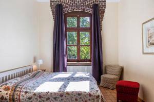 a bedroom with a bed and a window and a chair at Ferienwohnung Zum Alten Hengststall in Herleshausen