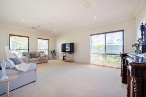 a living room with a couch and a tv at Thorby House - Comfort & Convenience, Pet Friendly in Dubbo