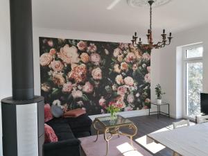 a living room with a floral wallpaper on the wall at Villa Seefried 5 Sterne in Malchow
