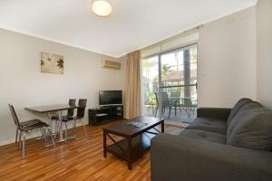 a living room with a couch and a table at Mandurah Motel and Apartments in Mandurah