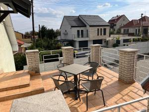 a patio with a table and chairs on a balcony at Petöfi Vendégház in Eger
