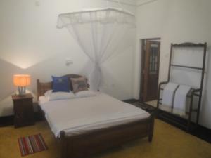 a bedroom with a bed and a window with a curtain at Priyanka Villa in Bentota