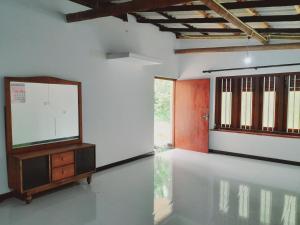 a room with a flat screen tv on a white wall at Rustic Villa 7 in Weligama